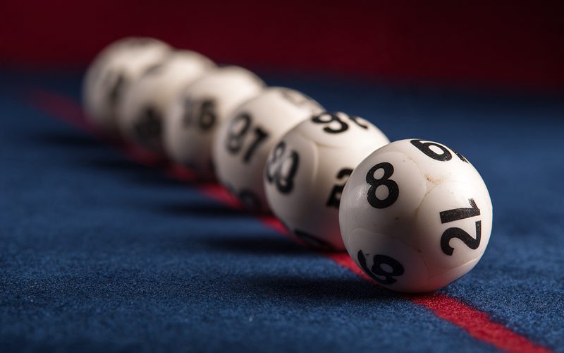 Seis bolillas numeradas del Quini 6 sobre paño azul